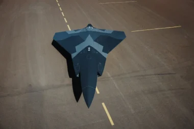 Top down view of a dark blue stealth jet on a runway seen from above