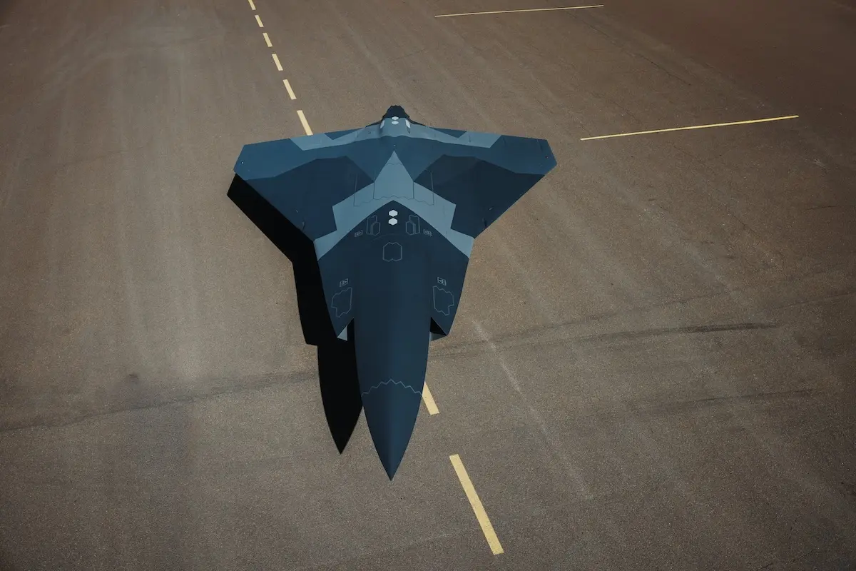 Top down view of a dark blue stealth jet on a runway seen from above