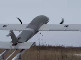 Propeller driven airplane mounted on a ground test rail with spinning blades outdoors in a field