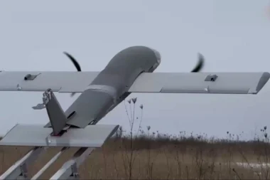 Propeller driven airplane mounted on a ground test rail with spinning blades outdoors in a field