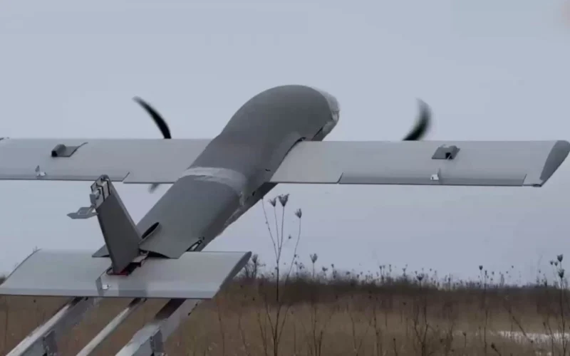 Propeller driven airplane mounted on a ground test rail with spinning blades outdoors in a field
