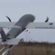 Propeller driven airplane mounted on a ground test rail with spinning blades outdoors in a field