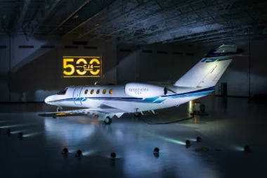 White Citation CJ4 private jet parked in a hangar with a yellow CJ4 Series sign on the wall