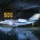 White Citation CJ4 private jet parked in a hangar with a yellow CJ4 Series sign on the wall