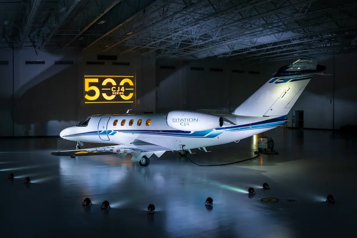 694708 0826 500th Cessna Citation CJ4 delivery 4fd240 original 1786991350 White Citation CJ4 private jet parked in a hangar with a yellow CJ4 Series sign on the wall