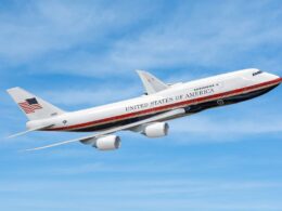 Airplane labeled United States of America mid flight against a blue sky