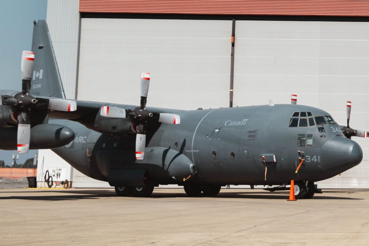 Coulson Aviation Canadian C 130 Acquisition Canada marked military C 130 Hercules turboprop aircraft on a tarmac in front of a hangar propellers visible on both wings