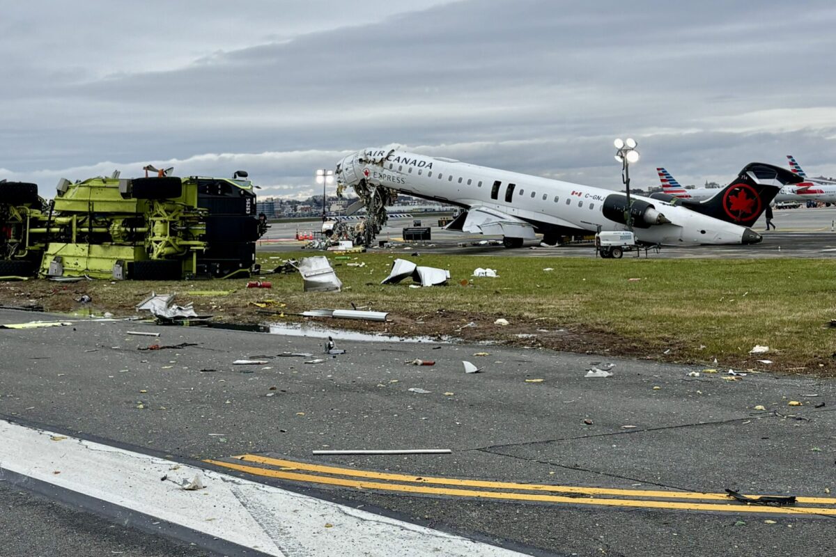 Air Canada Express jet with severe damage and surrounding debris on a runway overturned ground equipment nearby at a damaged airport scene