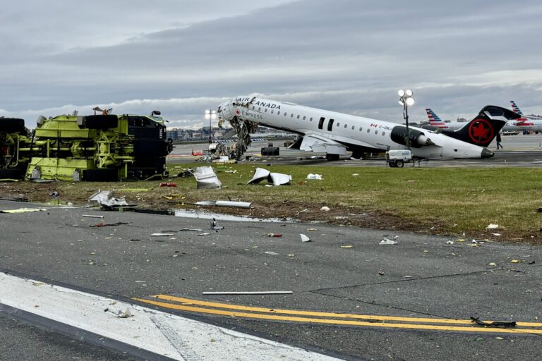 Air Canada Express jet with severe damage and surrounding debris on a runway overturned ground equipment nearby at a damaged airport scene