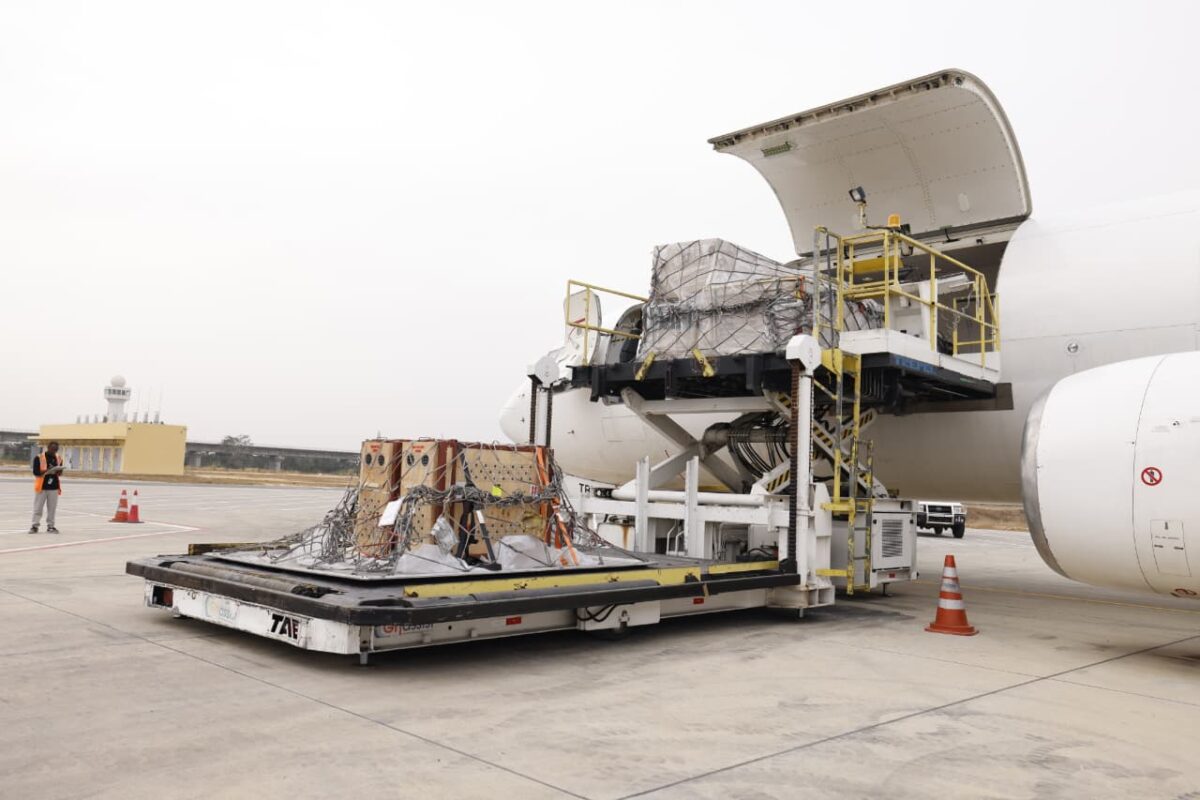 Cargo pallet loaded with wrapped cargo being lifted into a widebody airplanes aft cargo doorway on a ground loader at an airport