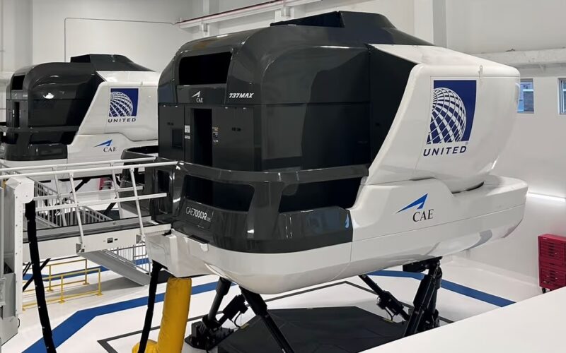 New United flight stimulators in Denver Inside a flight training hangar with multiple large United CAE flight simulators mounted on hydraulic bases