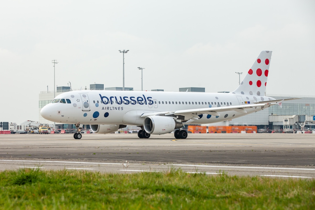 PJL BrusselsAirlines 26 Brussels Airlines passenger jet on the airport tarmac shown in a front three quarter view with a dotted red tail livery in the background