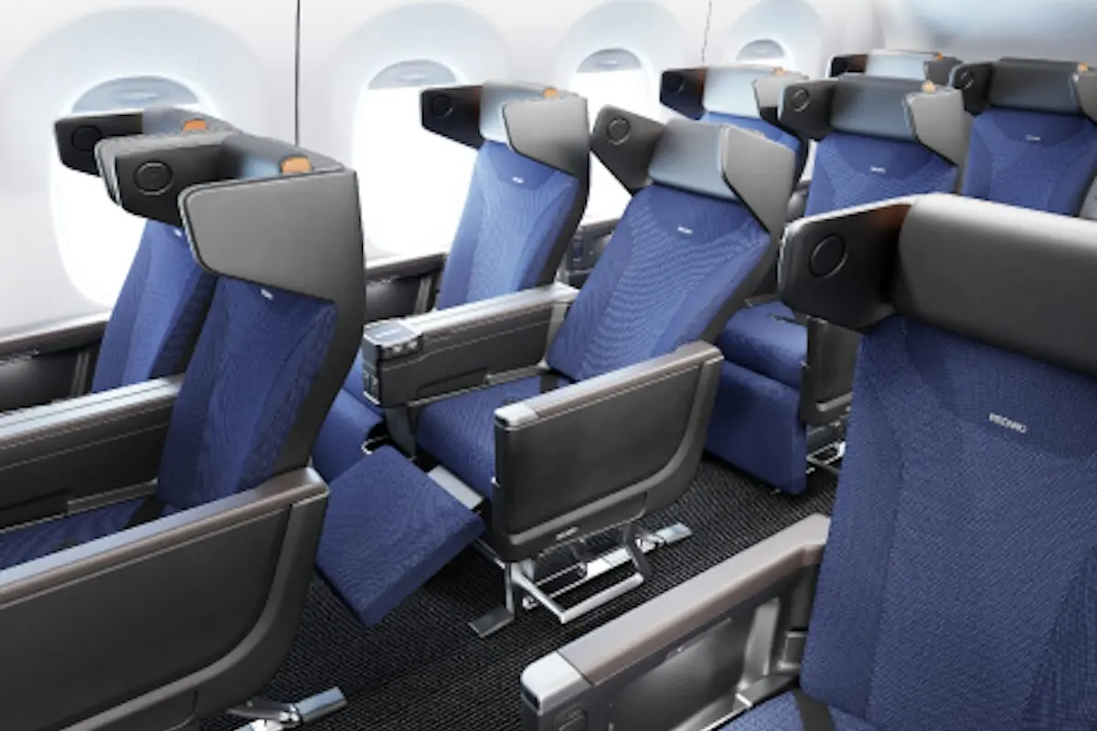 Interior of a commercial airplane cabin with multiple rows of blue fabric seats and headrests