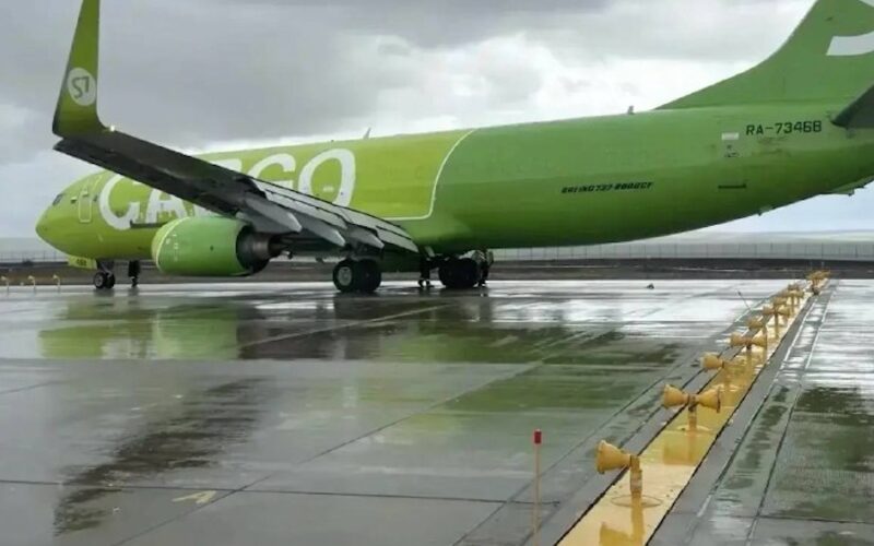S7 Norilsk overrun 3x2 Bright green passenger plane on a wet tarmac viewed from the side with engines under the wings