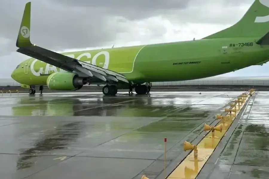 S7 Norilsk overrun 3x2 Bright green passenger plane on a wet tarmac viewed from the side with engines under the wings