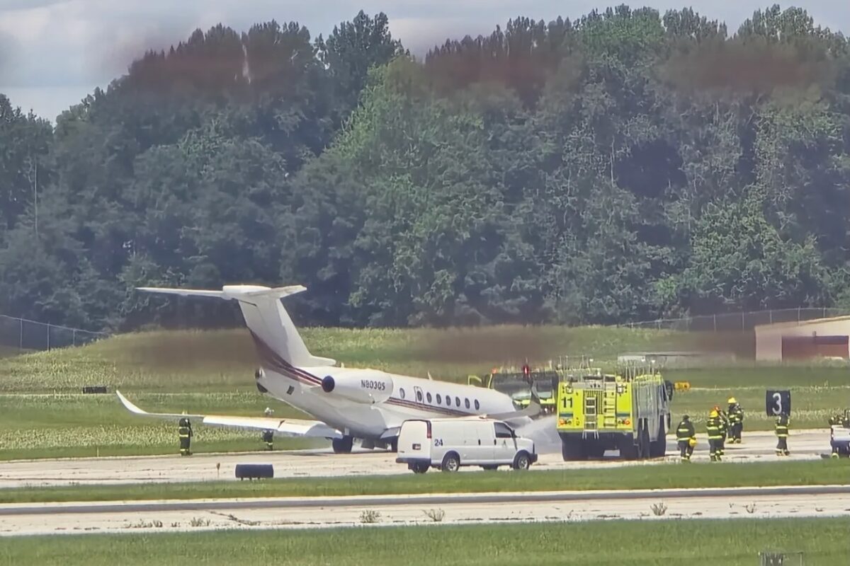 Screenshot White private jet on the runway with firefighters and a yellow fire truck nearby