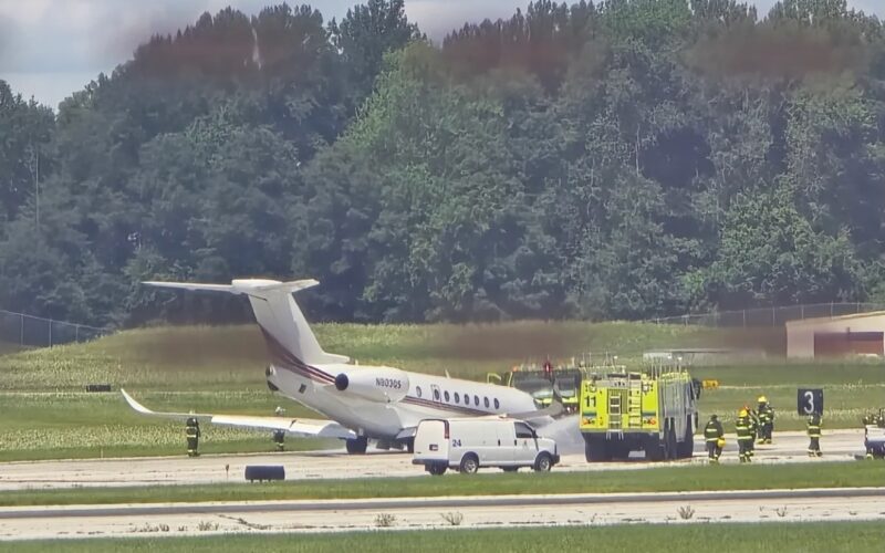 Screenshot White private jet on the runway with firefighters and a yellow fire truck nearby