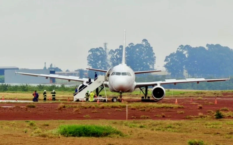 White passenger jet on a tarmac with mobile stairs attached to the forward door and ground crew nearby preparing for boarding