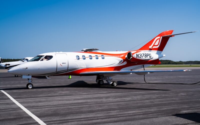 SyberJet Aircraft SJ30 2 Unofficial Speed Record 1280 1 White private jet with red and orange accents parked on a runway under a clear blue sky registration N378PG visible on the tail