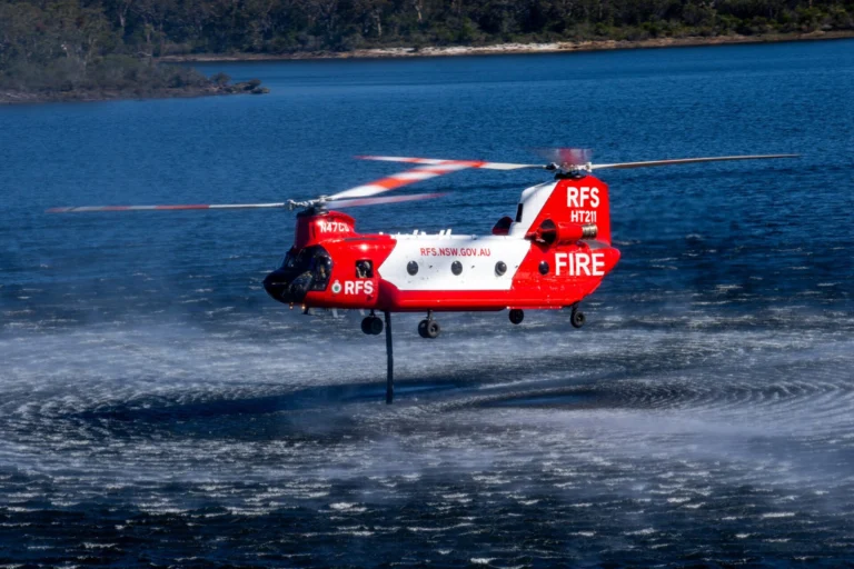 The NSW Rural Fire Services CH 47D Chinook HeliTak 211 N47CU uses its snorkel to refill its 11300 liter internal water tank