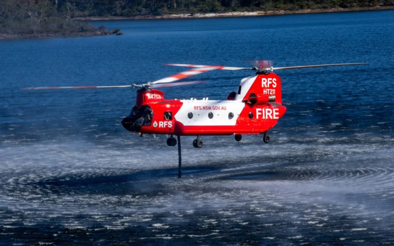 The NSW Rural Fire Services CH 47D Chinook HeliTak 211 N47CU uses its snorkel to refill its 11300 liter internal water tank