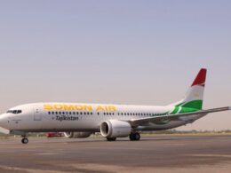 Somon Air jet on the runway with Tajikistan branding and a red green tail fin