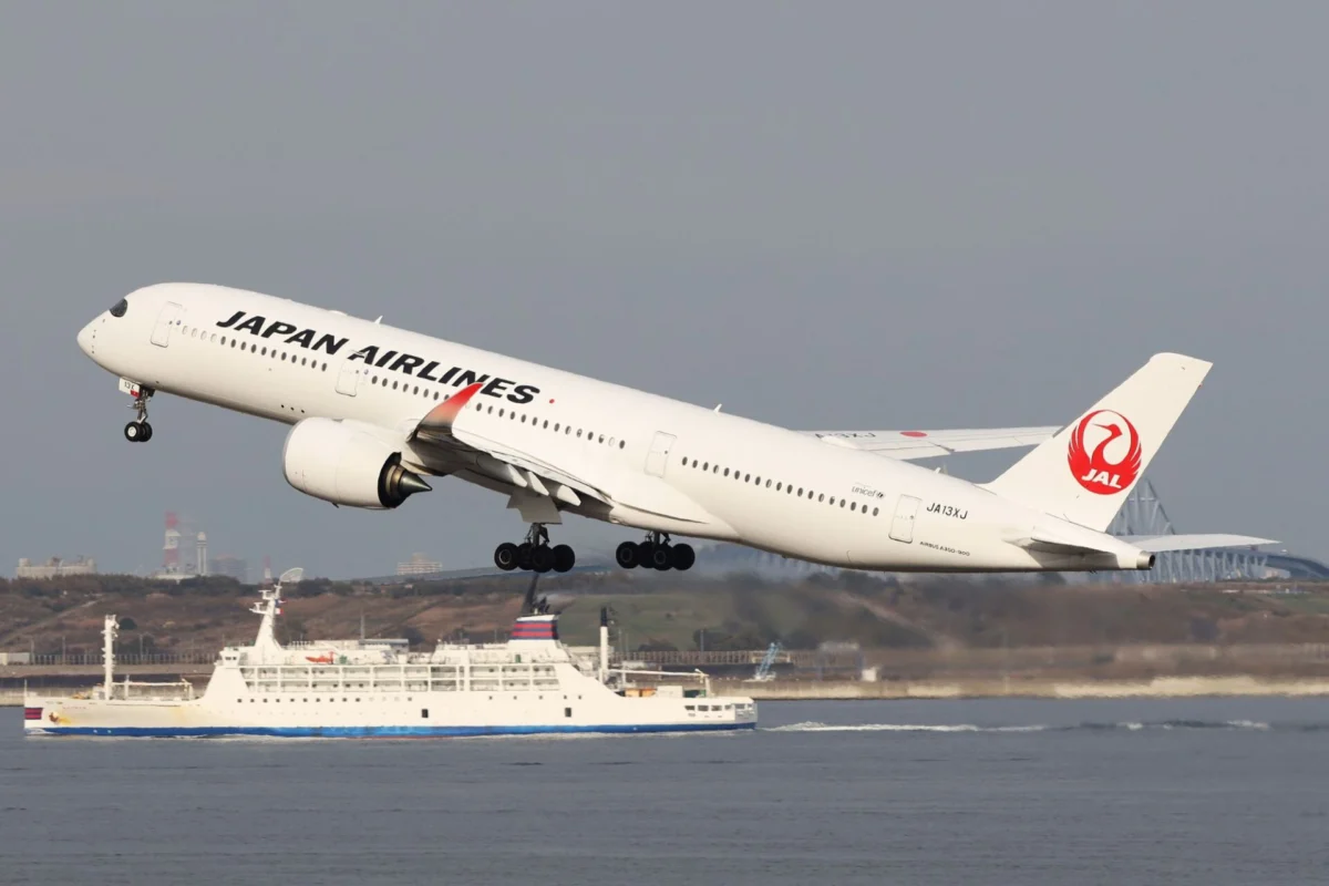 JAL joins pilot test to capture CO2 from seawater Japan Airlines jet taking off over the water side view with the red JAL crane logo on the tail