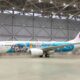 Japan Airlines plane in a hangar with a Disney themed livery featuring Mickey Mouse characters JAL red tail logo visible