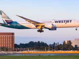 WestJet Boeing 787 Dreamliner landing with gear down over the runway during golden hour light tail visible