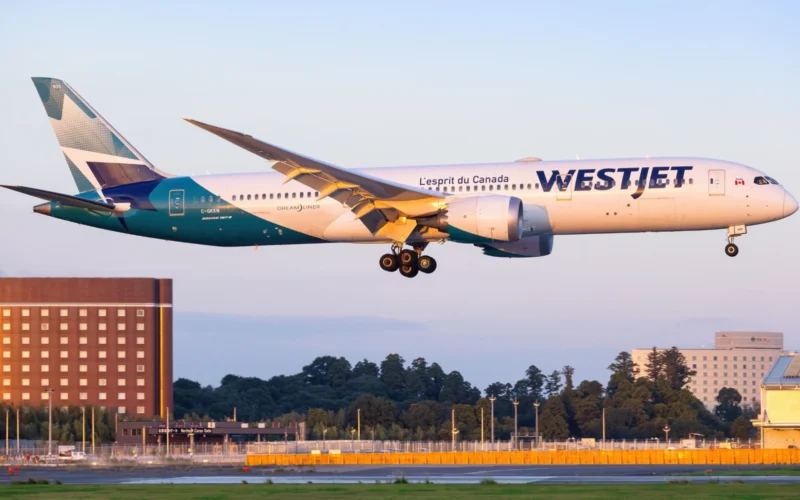 WestJet Boeing 787 Dreamliner landing with gear down over the runway during golden hour light tail visible