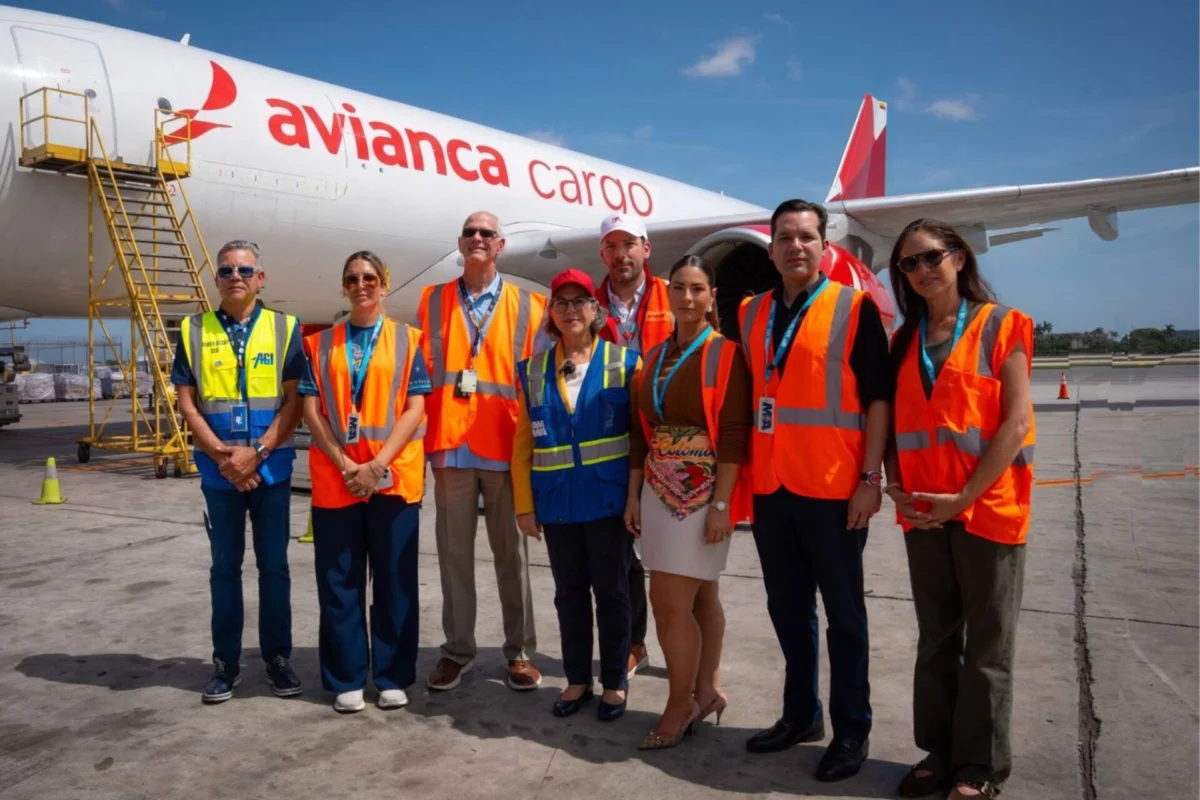 Avianca Cargo delivers 60 more tons of aid to Colombia Group of airport workers in orange vests posing in front of an Avianca Cargo plane on the tarmac