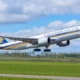 Singapore Airlines jet lifting off the runway with gear down blue sky and clouds in the background
