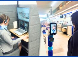 Agent with headset at a cubicle desk using dual computer screens for remote assistance