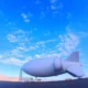Huge white airship hovering over an airfield with mountains in the distance Chinese news logo in the top left corner
