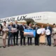 Group of airline staff and executives posing on the tarmac in front of a StarLux aircraft with travel signs