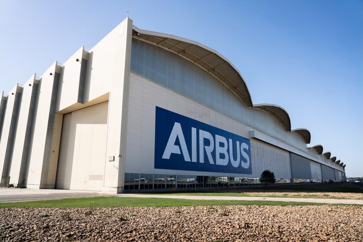 airbus Airbus hangar with a large blue Airbus logo on the white wall under a clear blue sky