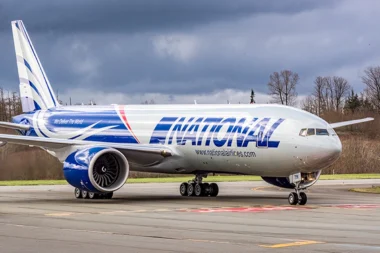 National Airlines wide body jet on a taxiway with engines visible under a cloudy sky