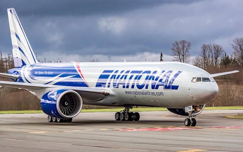 National Airlines wide body jet on a taxiway with engines visible under a cloudy sky