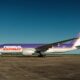 FedEx Express cargo plane with purple and orange livery on a taxiway under a clear blue sky