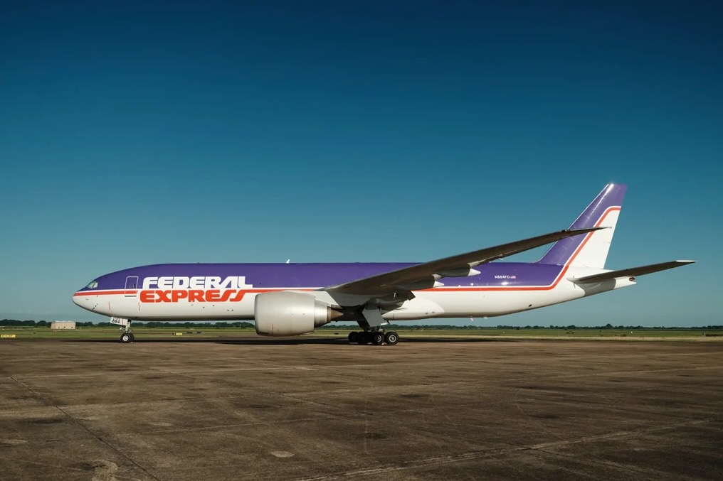 fedexs newly unveiled retro livery adorned by 777 n884fd v0 wzedlvmkotih1 FedEx Express cargo plane with purple and orange livery on a taxiway under a clear blue sky