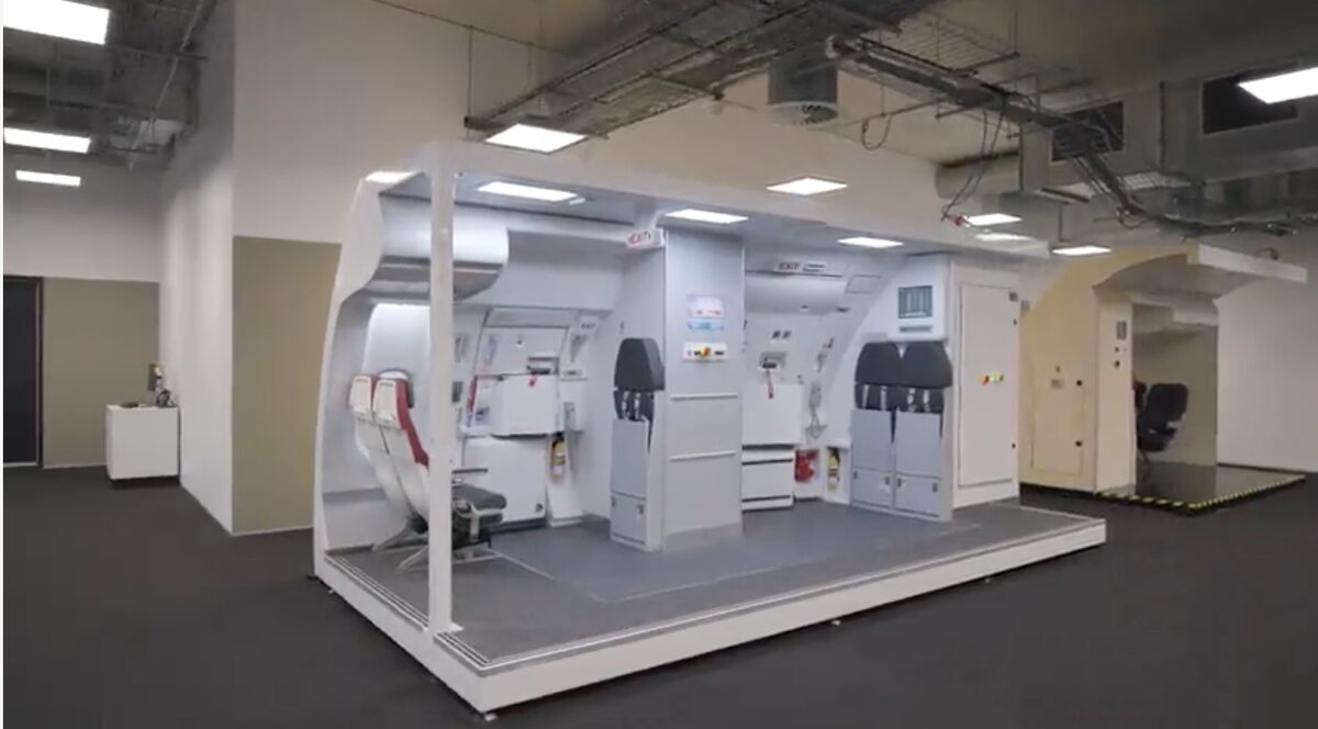 image Full scale aircraft cabin mock up on a raised platform in a training facility with seats panels and galley modules ready for practice scenarios in an industrial setting