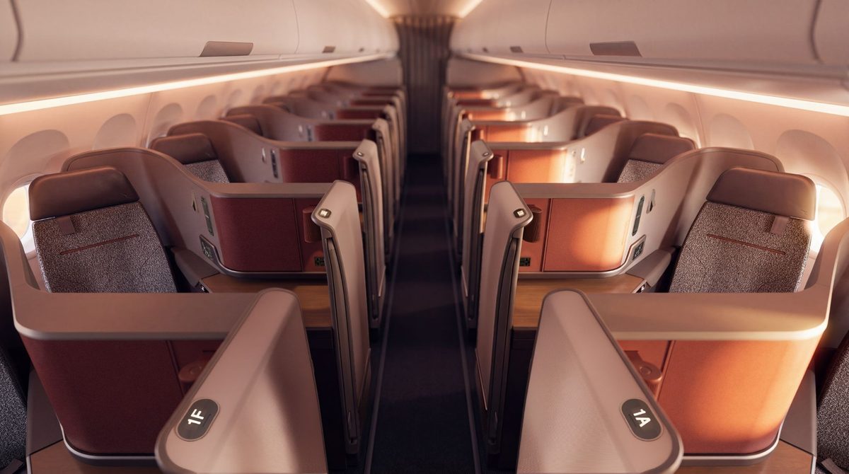image Lie flat business class seats in an airplane cabin rows along a center aisle with warm lighting and individual consoles visible 1A 1F