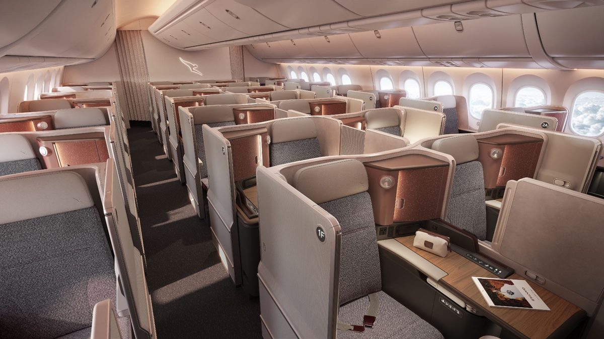 image Airplane cabin interior with lie flat business class seats beige and brown upholstery and wood toned desks