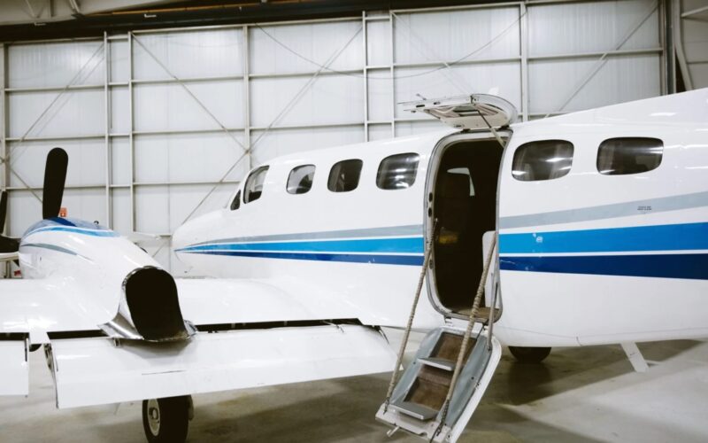 security aviation cover 1600x1000jpeg White private jet with blue stripes inside a hangar stairs deployed at the open door