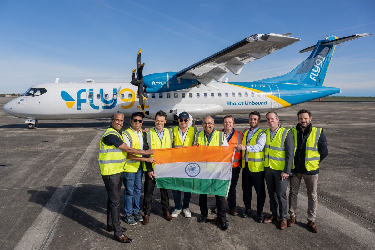 1788532447667 Group of airline staff in safety vests posing with the Indian flag in front of a Fly9 turboprop on the tarmac