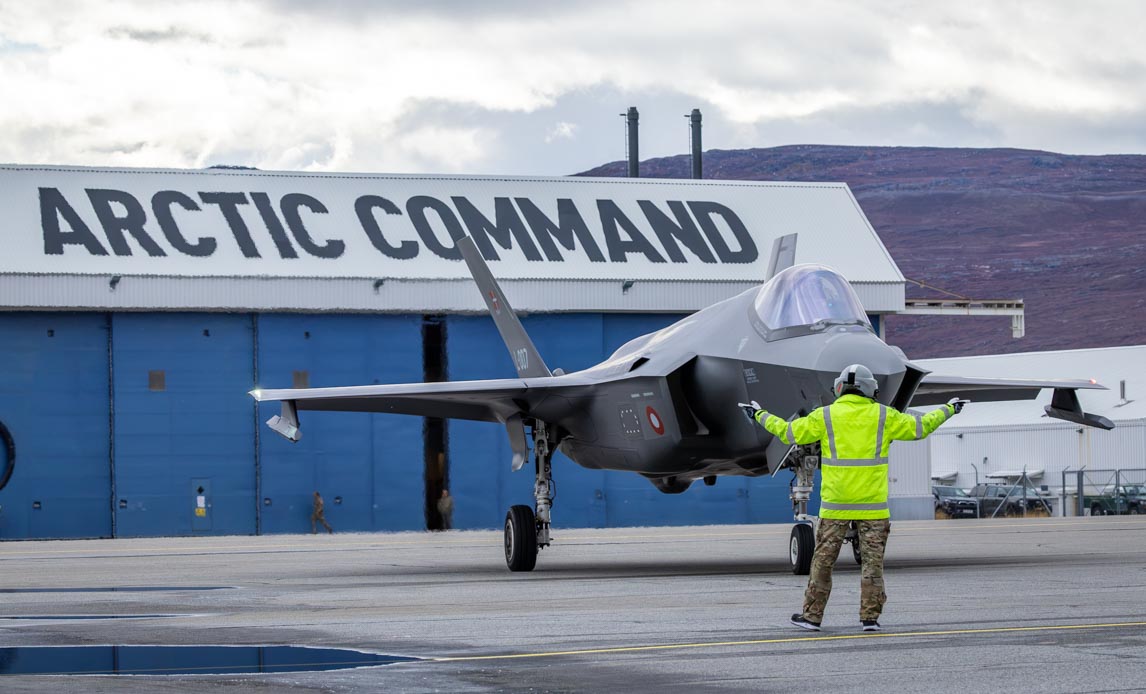 A Royal Danish Air Force F 35A is marshalled in front of the Joint Arctic Command facility at Kangerlussuaq Airport Greenland