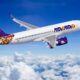 Air Cairo passenger jet flying above the clouds with purple logo and yellow purple tail design visible
