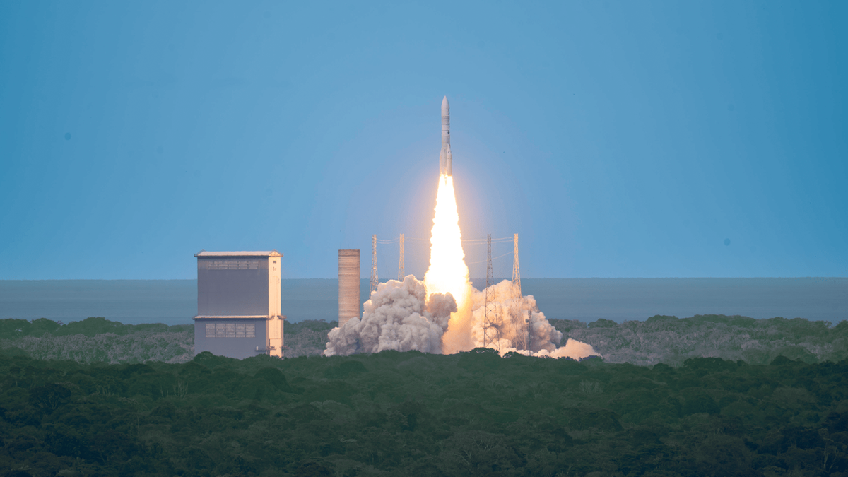 Ariane 6 lifts off on its inaugural flight VA262 from Europes Spaceport in French Guiana Rocket launches vertically from a coastal launch pad with a blazing fiery plume and surrounding launch towers against a blue sky and forest foreground