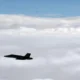 Finnish Air Force FA 18 Hornet flies alongside a formation of Russian military aircraft over the Gulf of Finland