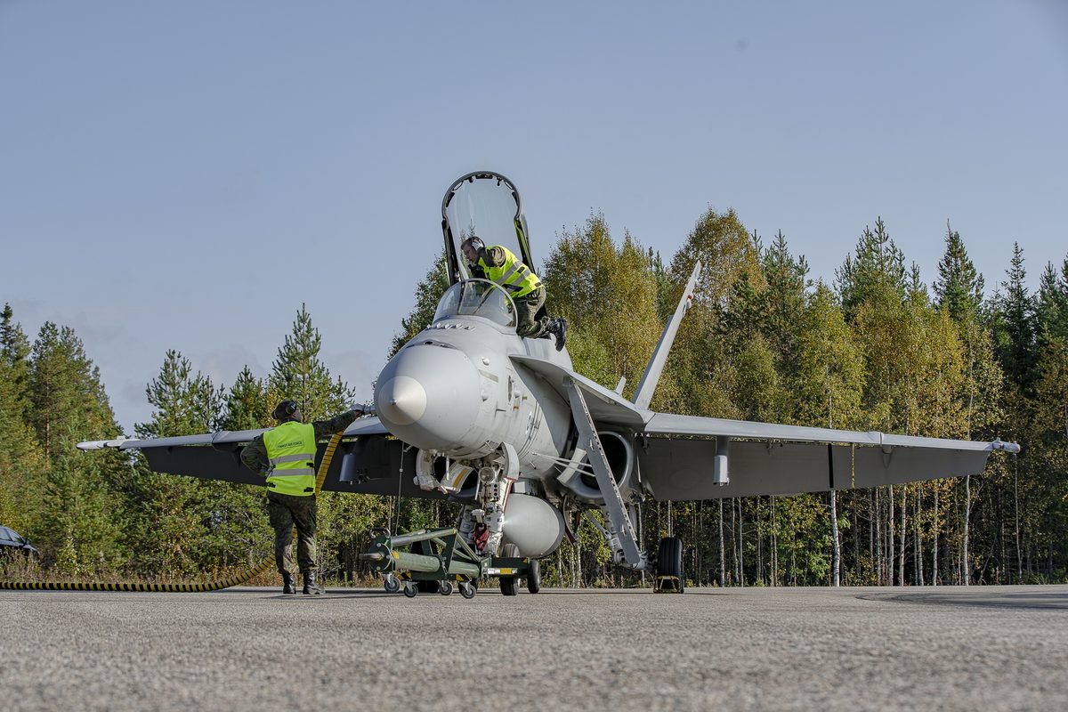 US Air Force F 35 Lightning II makes historic first on highway in Finland Military jet on the tarmac with two ground crew in high visibility vests inspecting the cockpit hatch and surrounding equipment